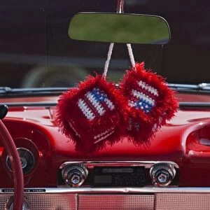 USA, Massachusetts, Gloucester. Fuzzy dice with US flag in 1950s-era convertible, antique car show
